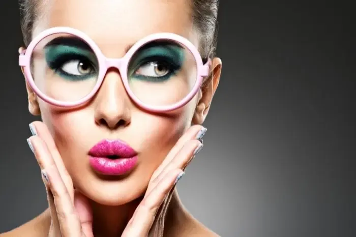 Femme portant des lunettes de vue avec un maquillage travaillé, illustrant comment se maquiller avec des lunettes