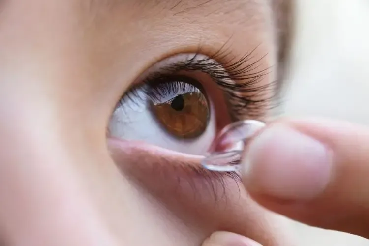 Personne mettant une lentille de contact spéciale pour port de nuit pour corriger la vue pendant le sommeil