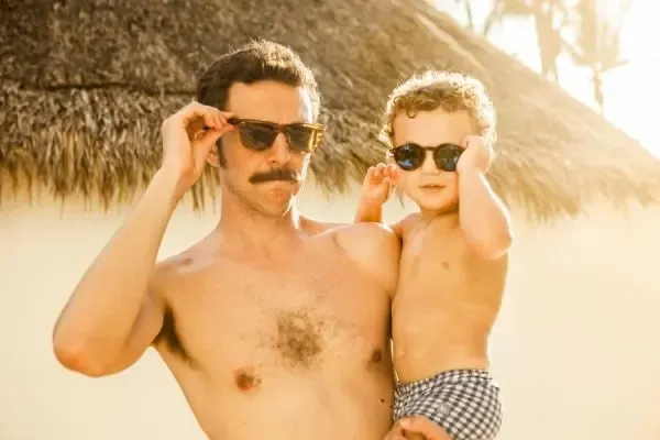 Papa et bébé portant des lunettes de soleil pendant leurs vacances pour protéger leurs yeux du soleil