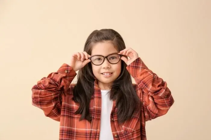 Jeune fille portant des lunettes trop grandes pour sa correction