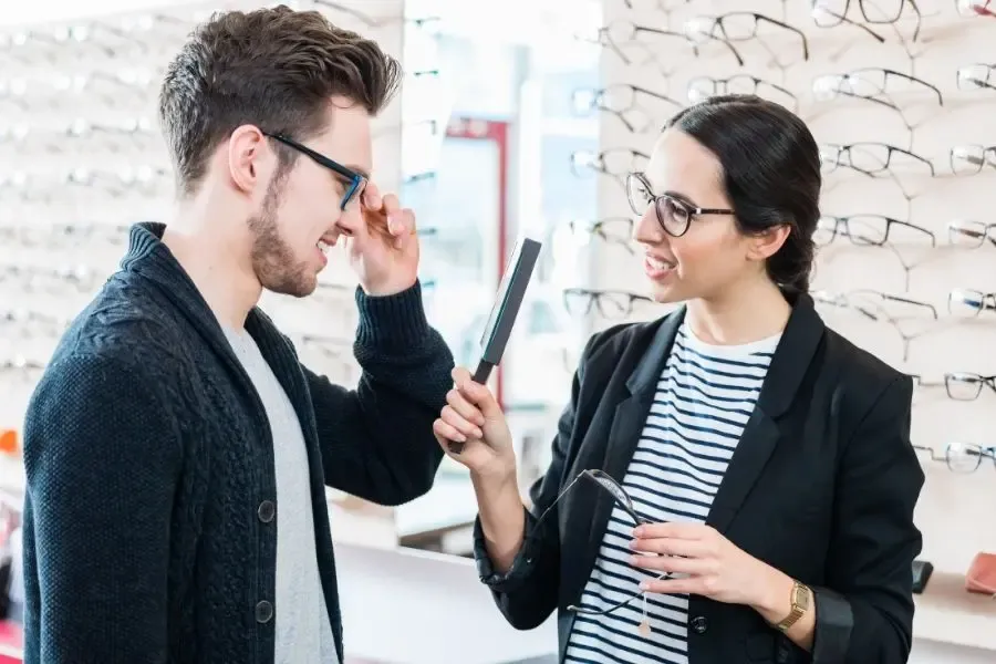 Client et opticien choisissant ensemble une monture de lunettes adaptée au style et à la vision
