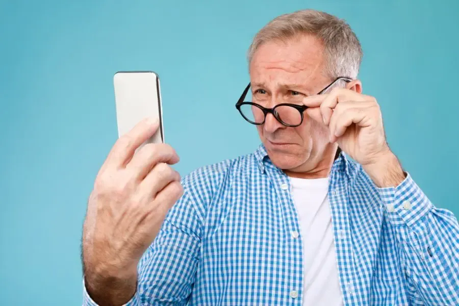 Homme atteint de DMLA portant des lunettes loupes pour améliorer sa vision de près