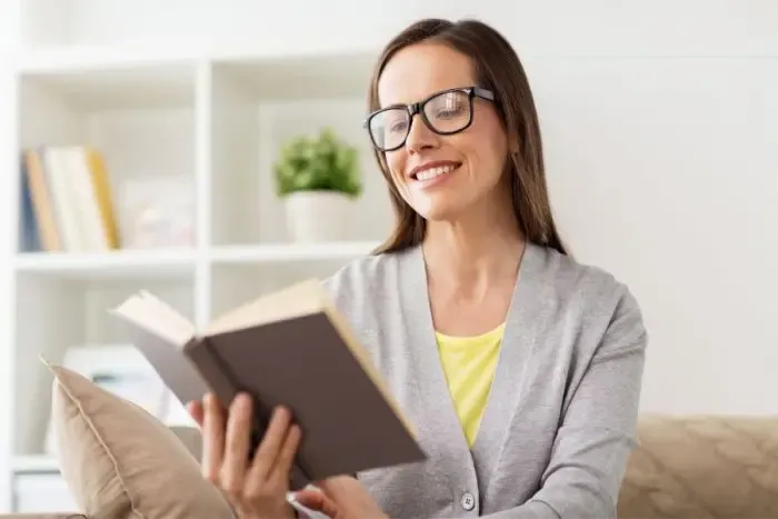 Femme lisant un livre avec ses lunettes de repos pour soulager la fatigue visuelle
