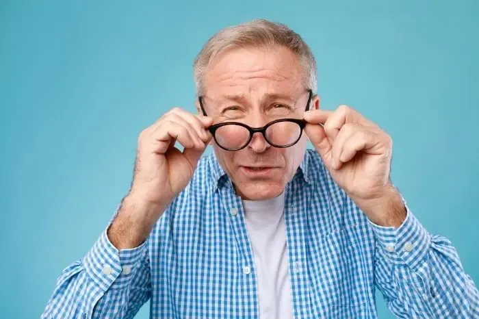 Homme ressentant un inconfort avec ses lunettes de vue, illustrant une correction inadéquate
