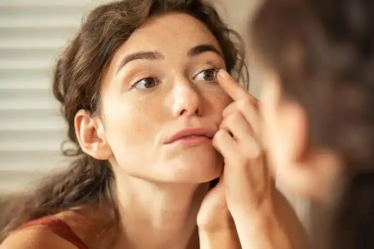 Femme mettant une lentille de contact sur son œil pour corriger sa vision