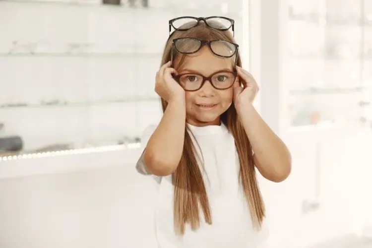 Enfant essayant des lunettes pour découvrir le style et l’effet rajeunissant des montures