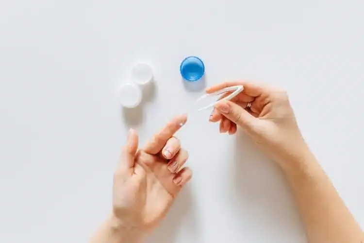 Manipulation d’une lentille de contact avec une pince spécialisée et un blister sur une surface propre