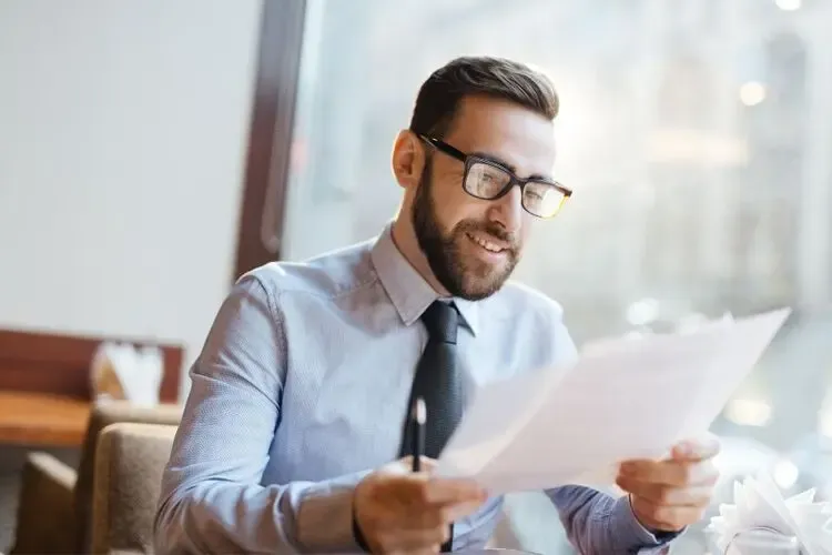 Homme lisant attentivement son ordonnance de lunettes pour comprendre sa correction visuelle