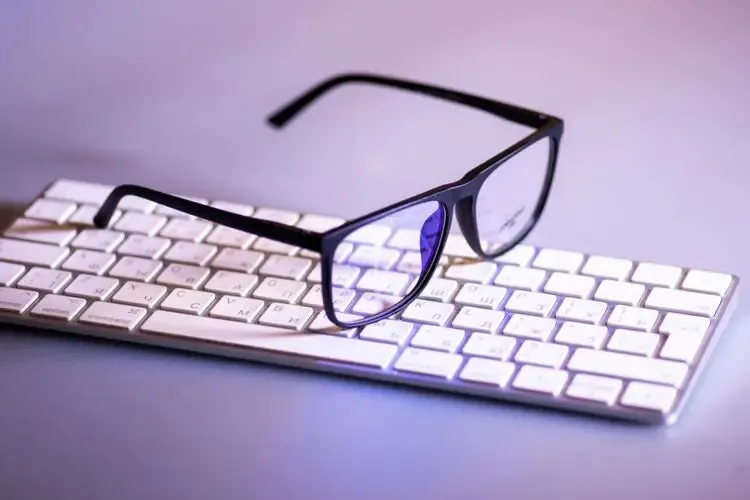 Paire de lunettes anti-lumière bleue posée sur un clavier pour protéger les yeux devant les écrans