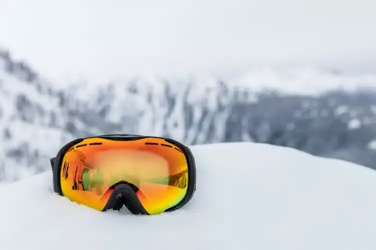 Masque de ski posé dans la neige pour protéger les yeux du soleil et de la réverbération