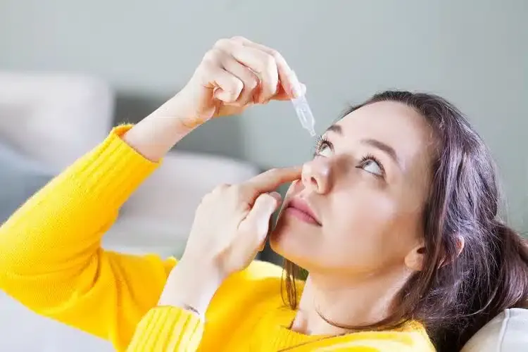 Femme appliquant des gouttes dans l’œil pour soulager la sécheresse et l’irritation oculaire