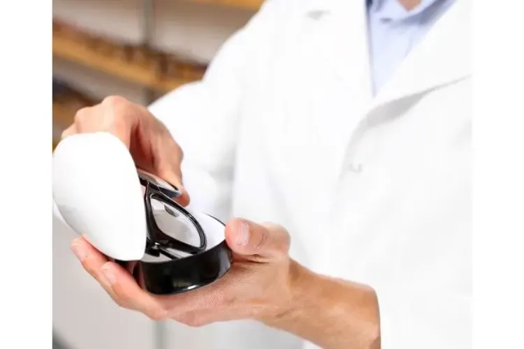 Opticien tenant une paire de lunettes pour conseiller son client sur le choix de la monture