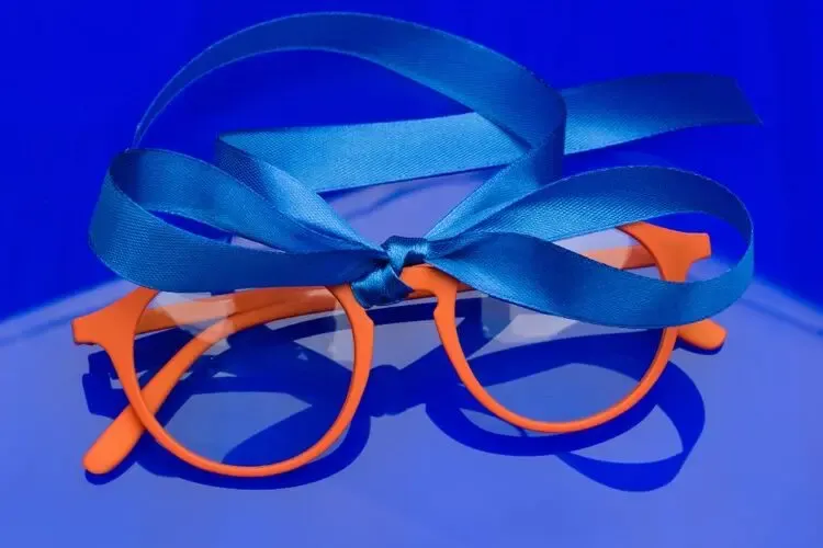 Paire de lunettes emballée avec un nœud de cadeau pour illustrer le renouvellement annuel des lunettes